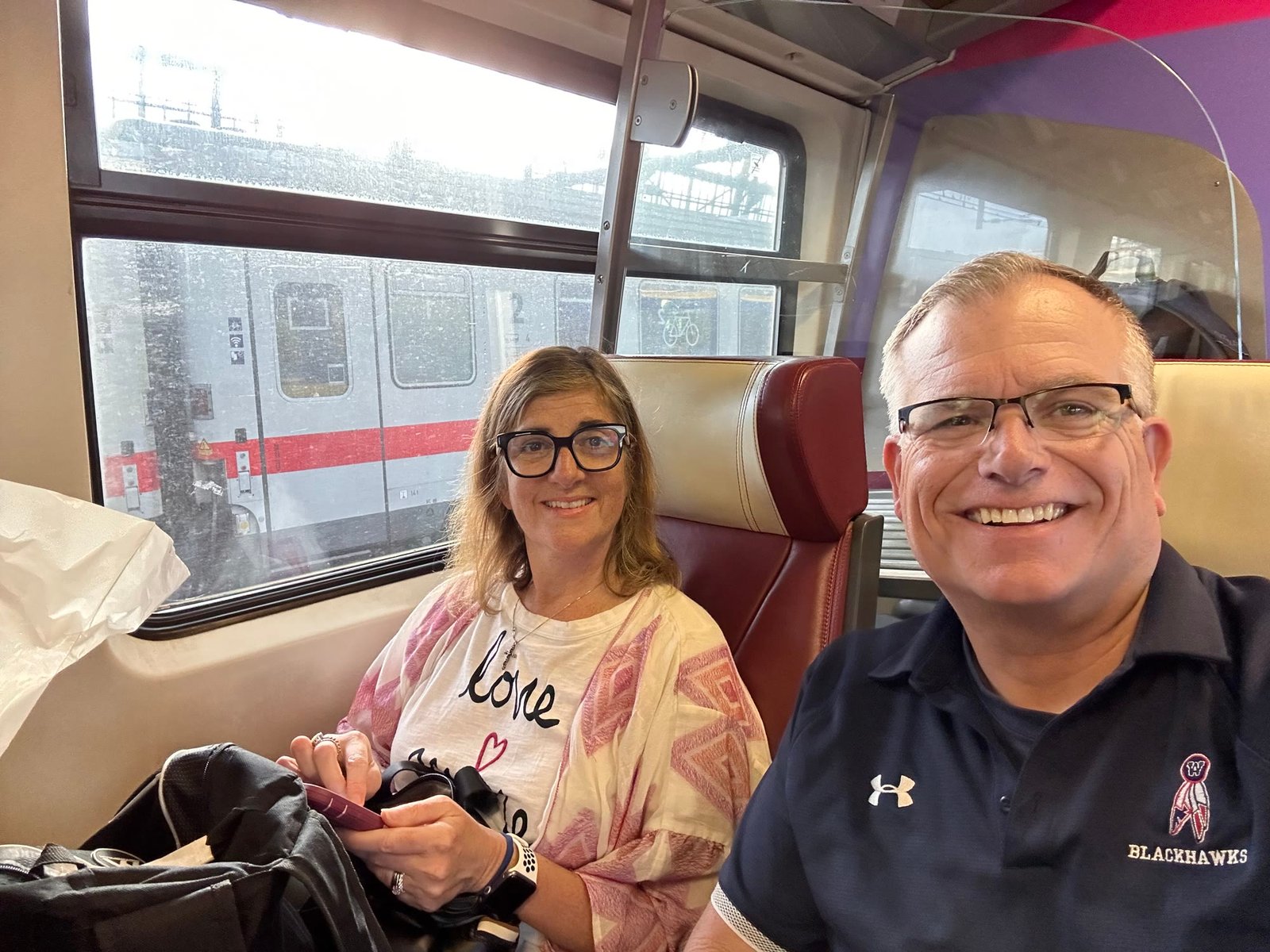 Chuck and Leslie smiling on a train