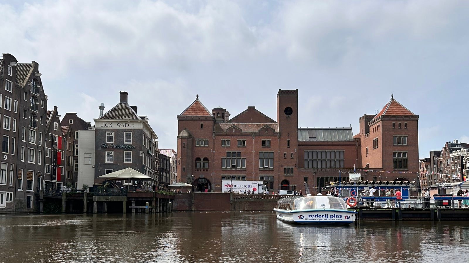 Canal boat on the Damrak with historic Amsterdam buildings