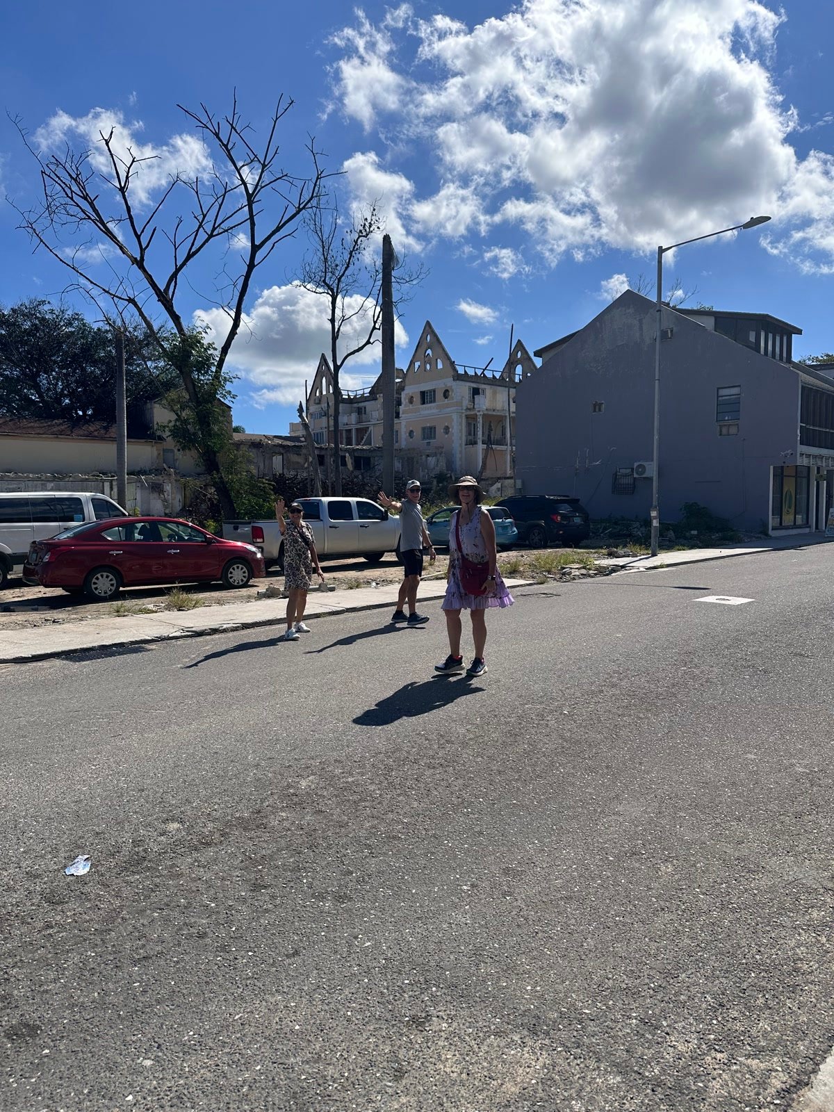 Friends waving on a sunny Nassau street