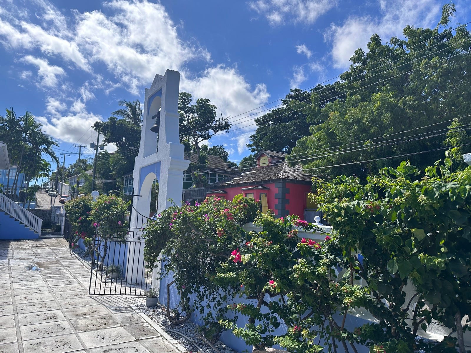 Pink colonial building, white bell tower, and bright bougainvillea on a Nassau street