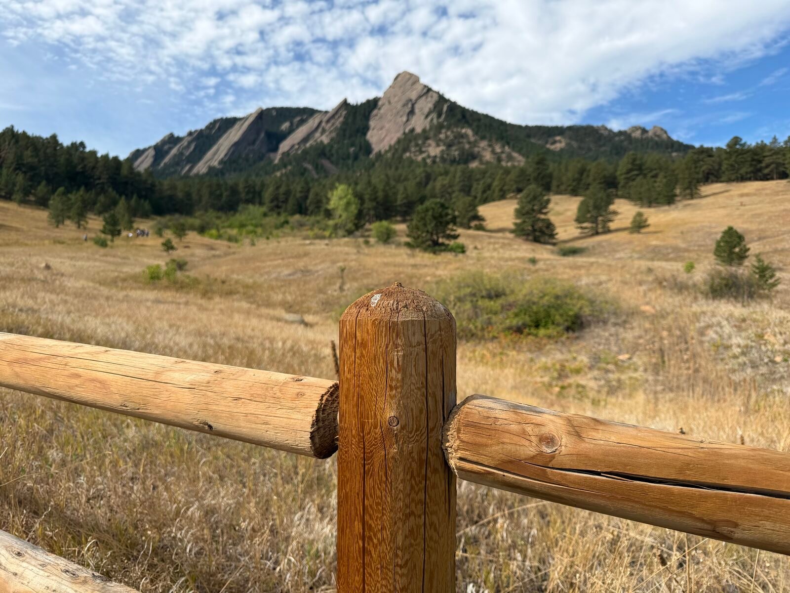 Flatirons framed through a fence post