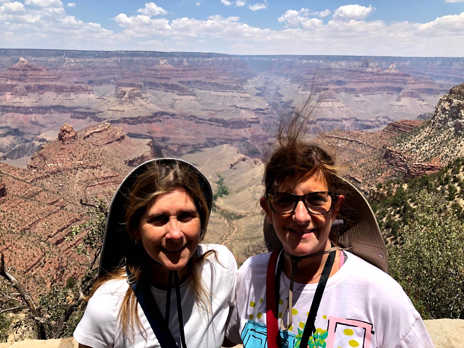 Friends smiling at a Grand Canyon rim overlook