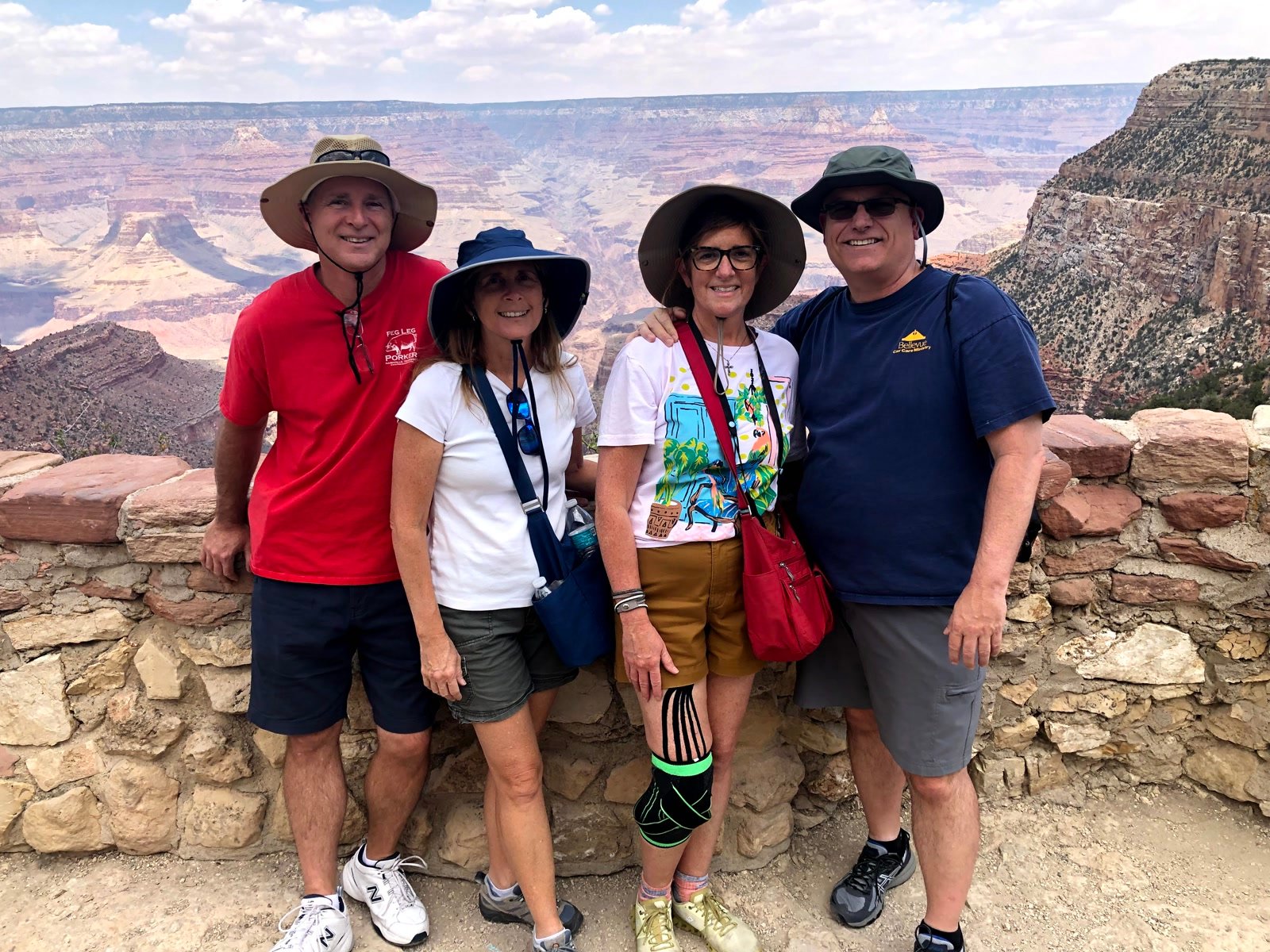 Four friends standing at a Grand Canyon rim overlook