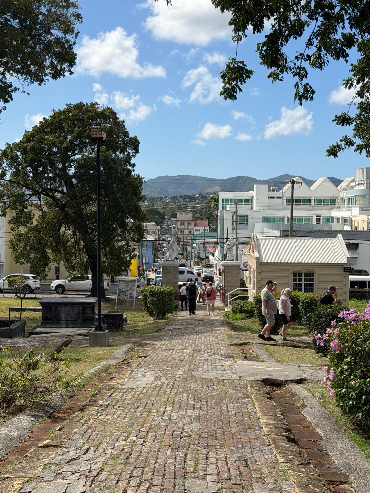Brick path through a hillside cemetery overlooking town in Antigua