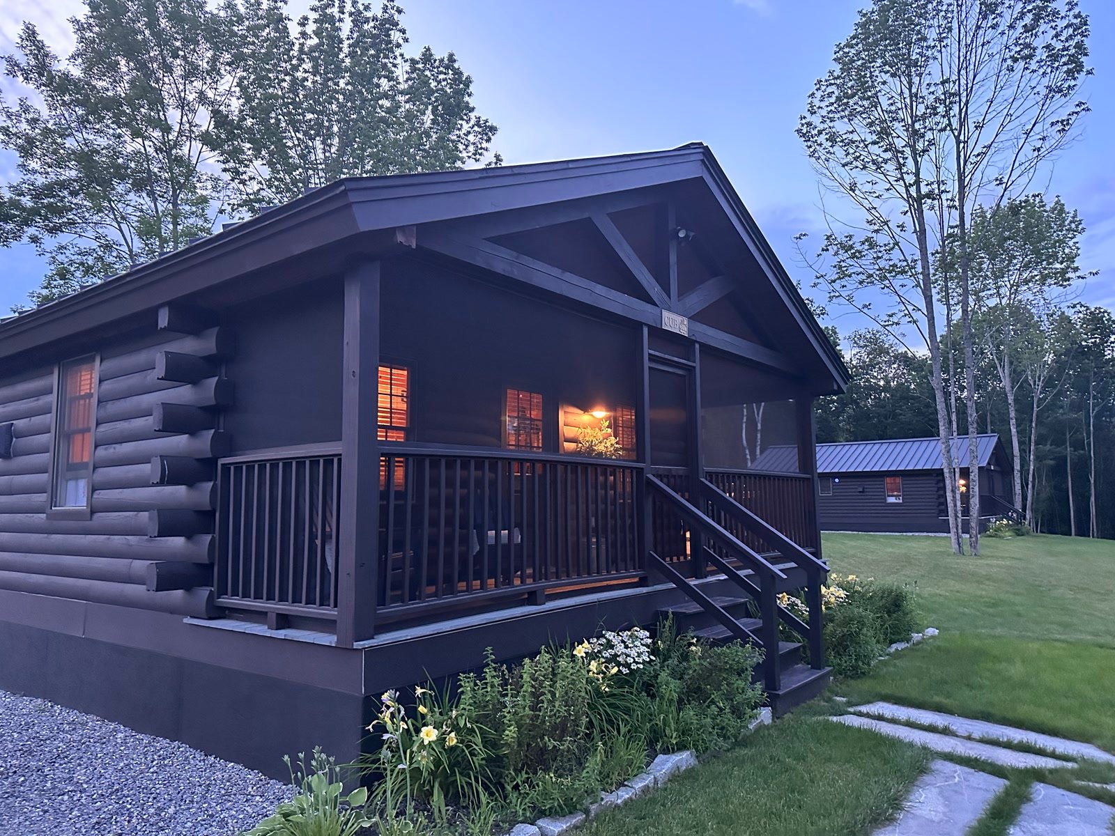 Log cabin glowing at dusk in Maine