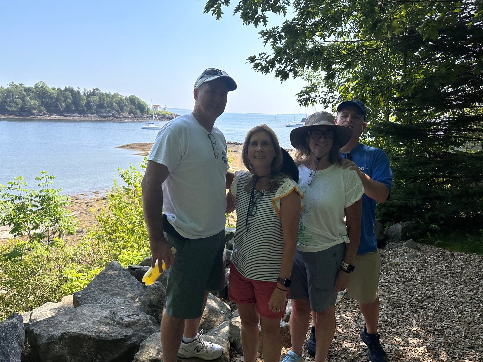 Rick and Tracey Bryant with friends on a rocky Maine shoreline