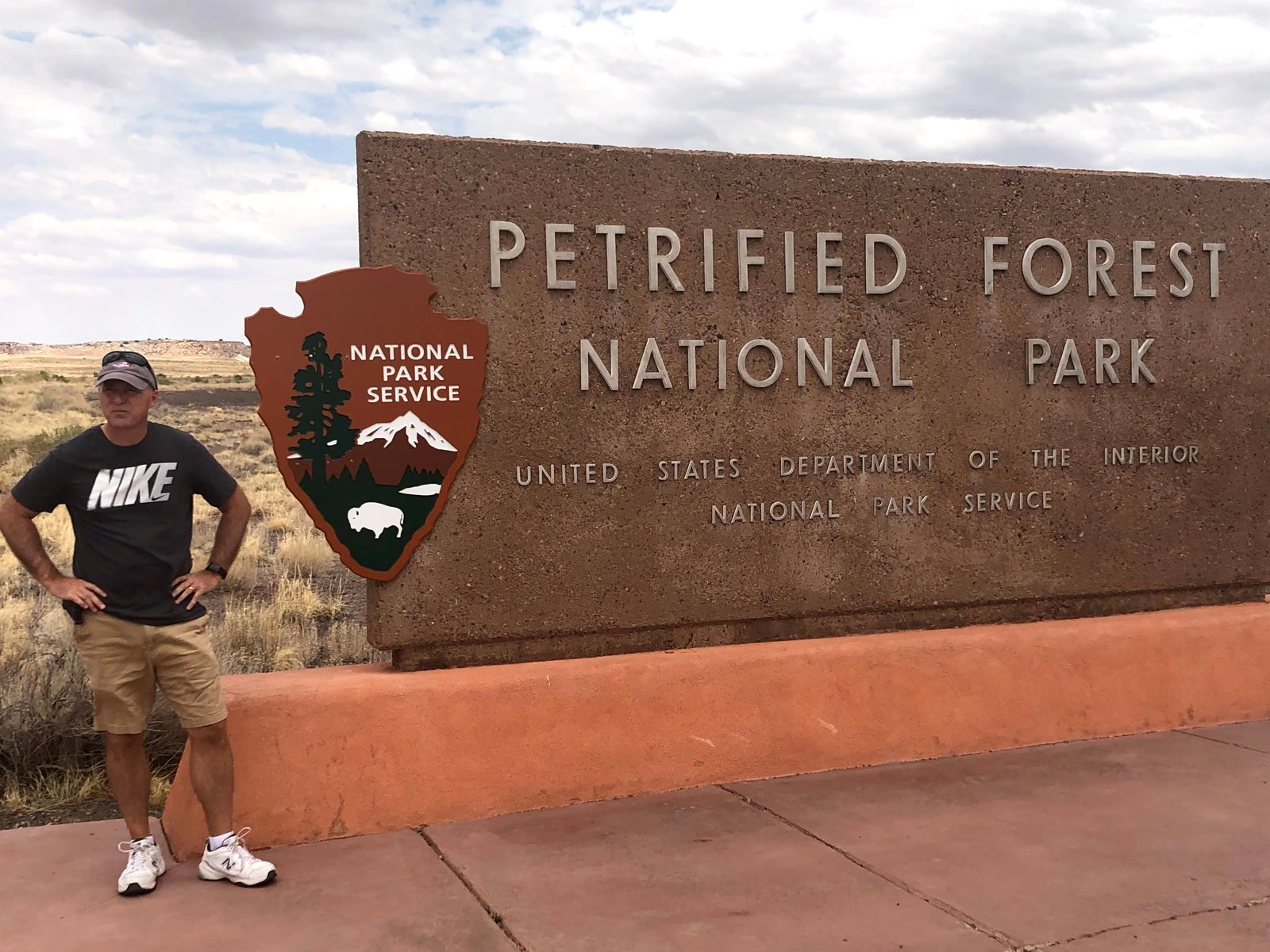 Chuck beside the Petrified Forest National Park entrance sign