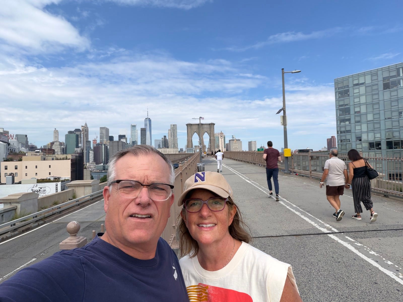 Chuck and Leslie walking the Brooklyn Bridge with the Manhattan skyline