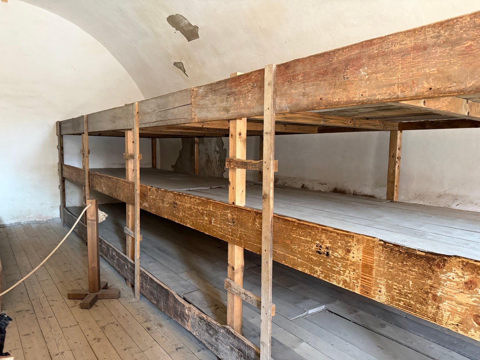 Three-tier wooden bunks in a cell at the Small Fortress, Terezín Memorial